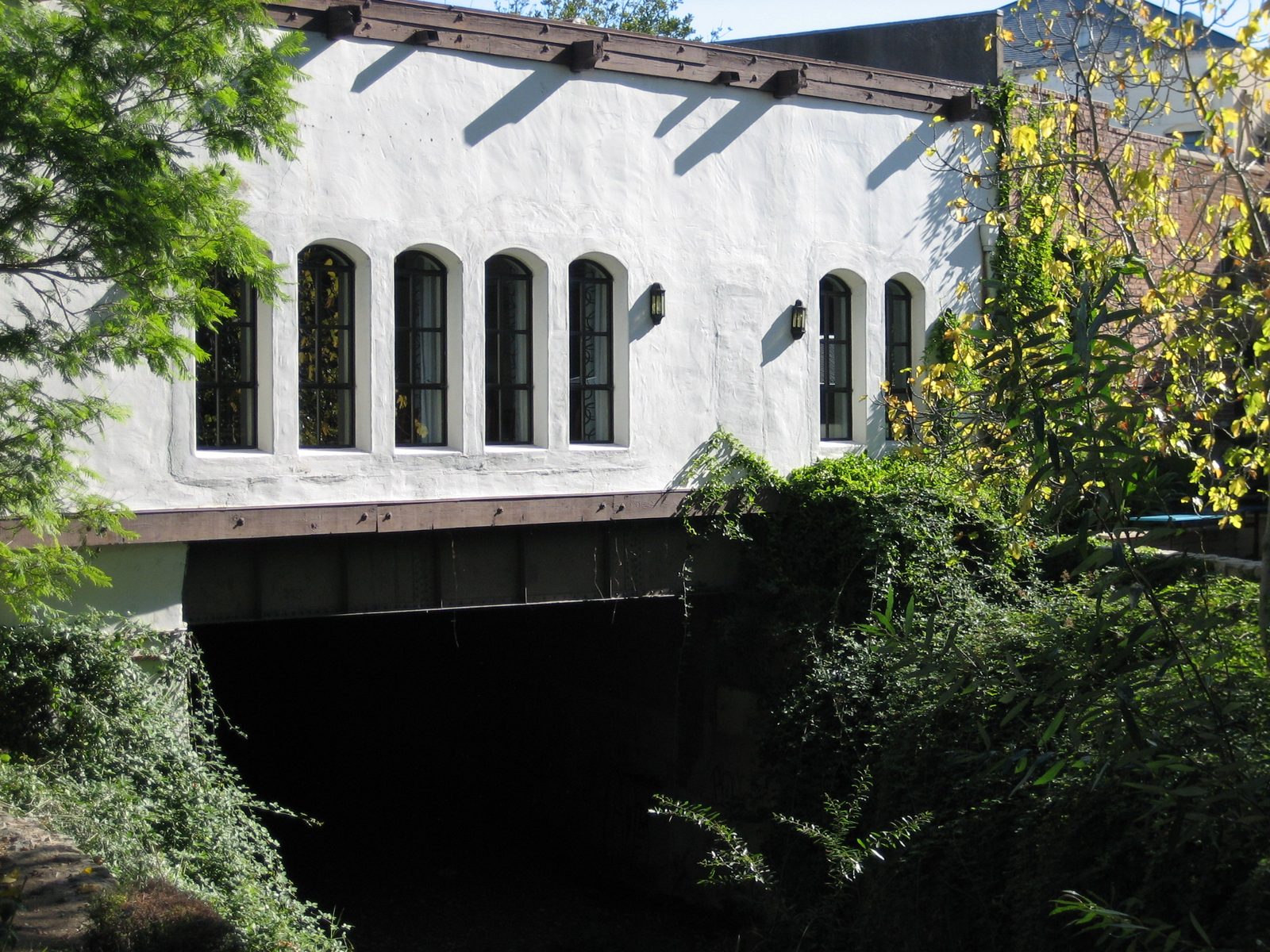Bridge over the creek in SLO, with buildings on the side of the road above.  From the street,...