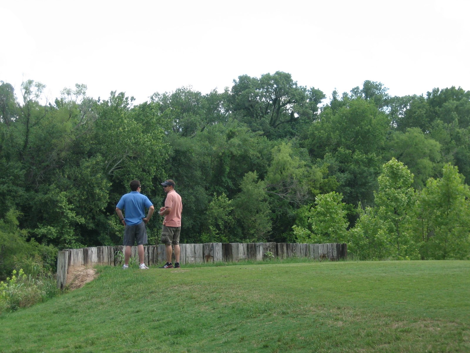 Eric and jay ponder the yonder (in this case, a river just beyond that wall).