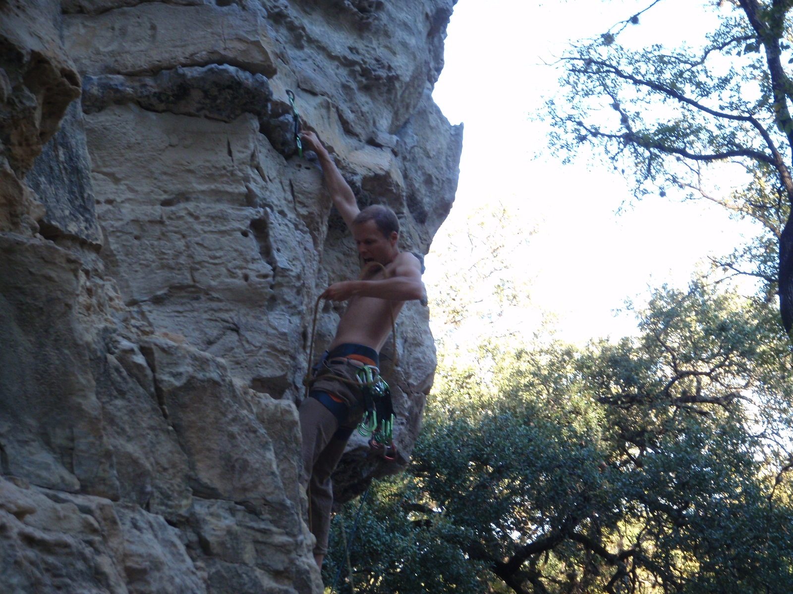 John releases the rope from his mouth as he has it with his hand, ready to clip.