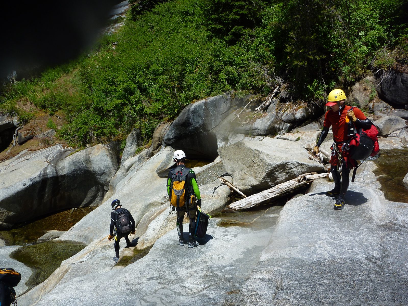 Tommer, Jon, and John downclimb in the water course.  Monica's backpack visible at left.