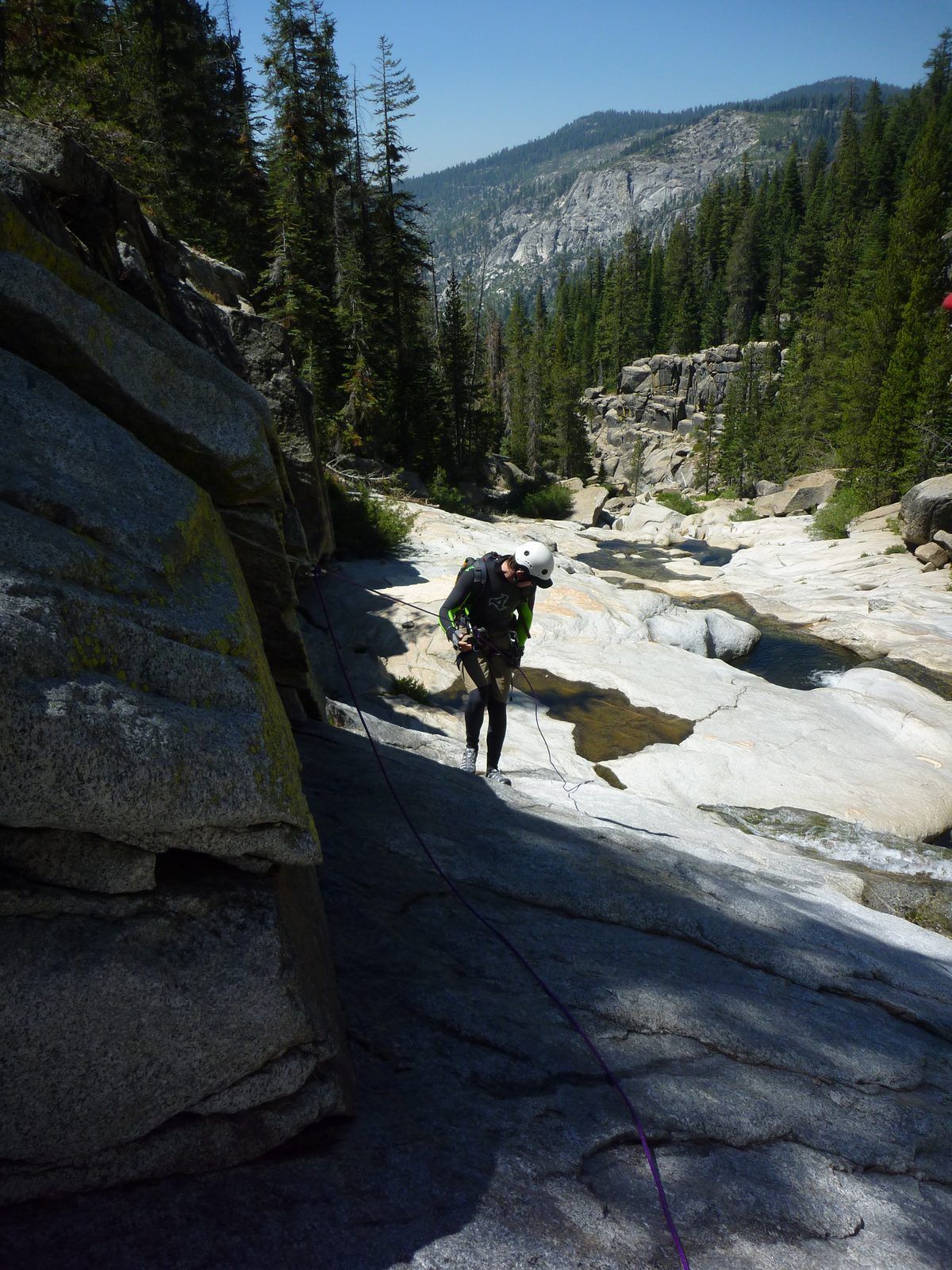 Jon begins the first rappel, a slabby descent with a short steeper section.