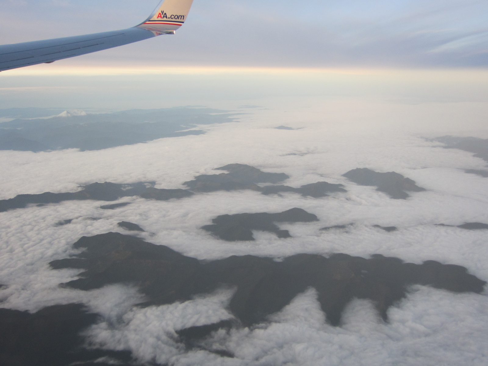 An ocean of low-lying clouds forms mountain-islands on the flight from SEA to AUS.