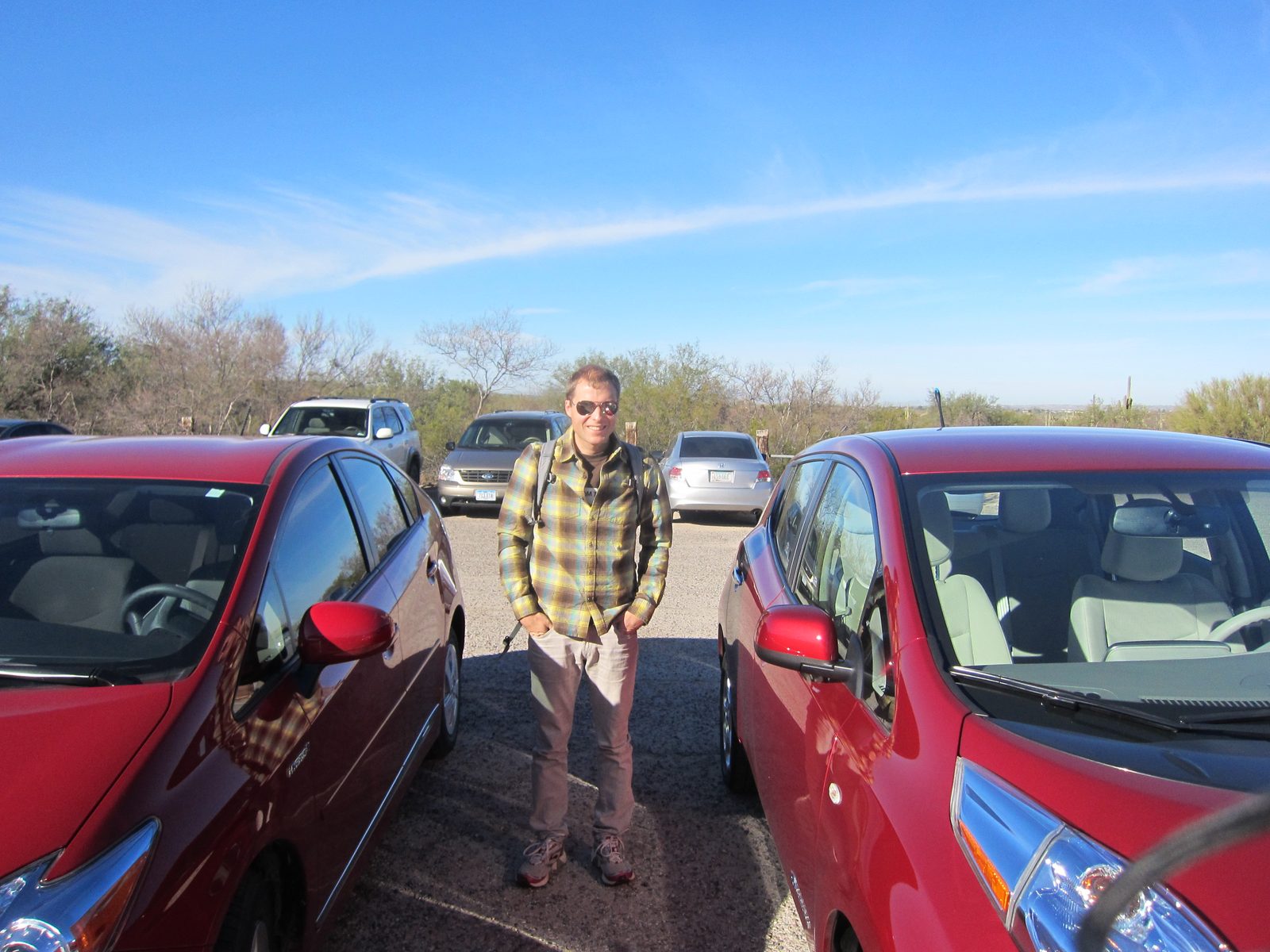 John stands by the Leaf and a very similarly-colored Prius.  And I think the camera strap got in the way.