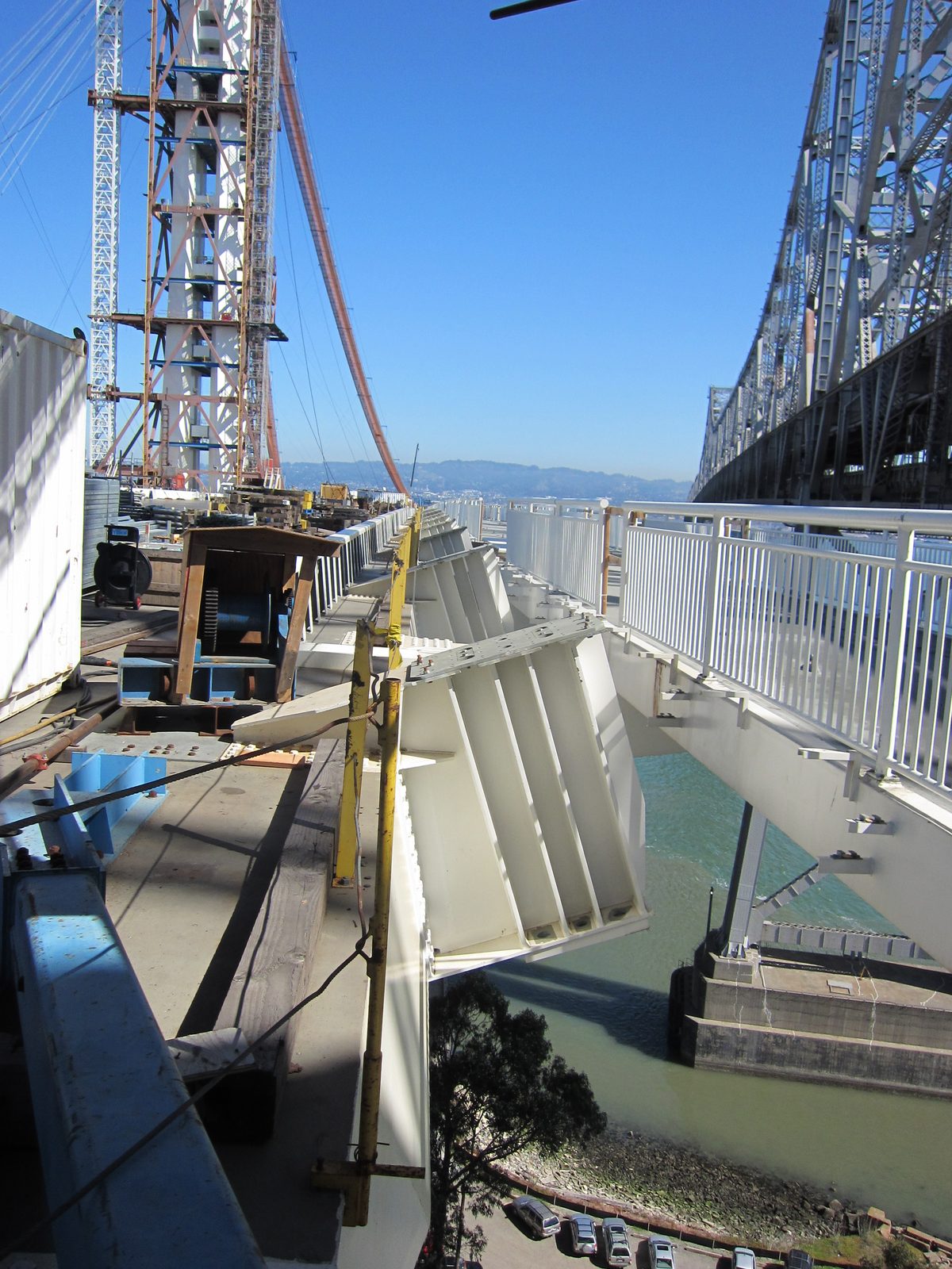 The angled white structures off the side of the deck are the hanger cable attachments.  From the...