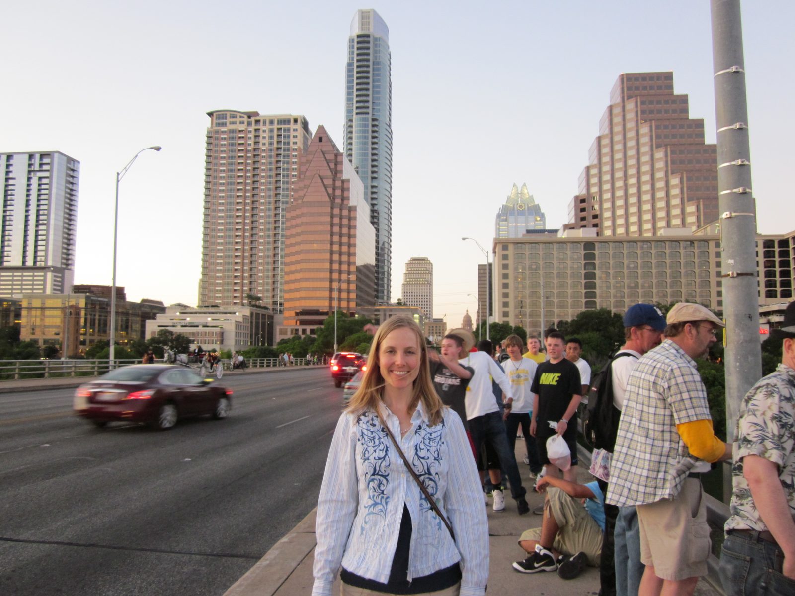 Diana waiting for the bats on the Congress Ave bridge with downtown Austin behind her.