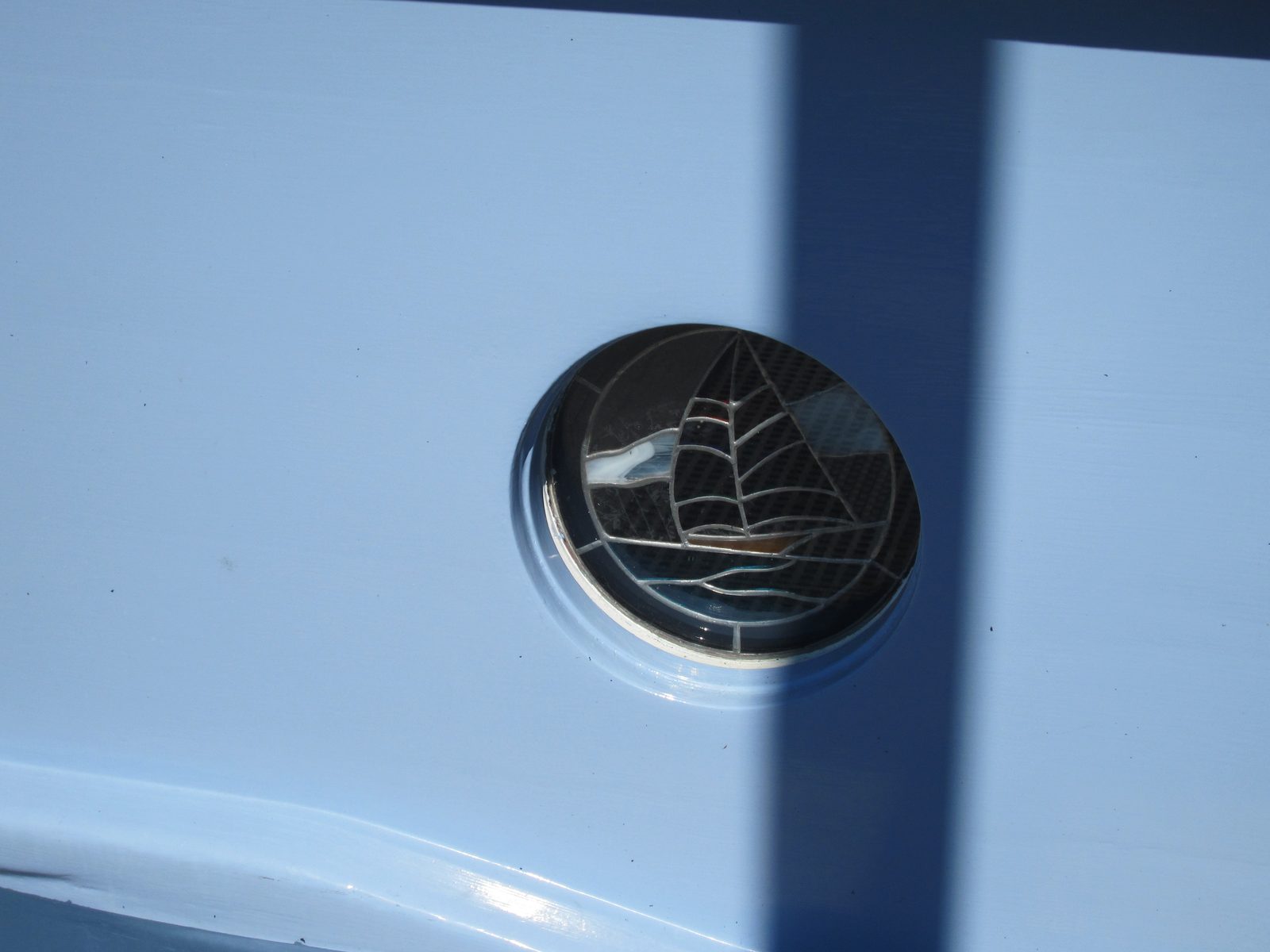 Teeny tiny stained glass porthole window.