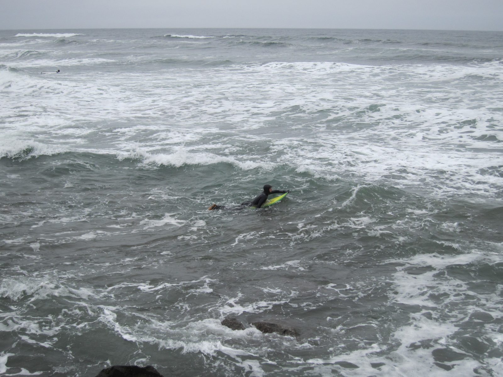 A surfer paddles out.  You can imagine, looking at him, why sharks view surfers and see seals.
