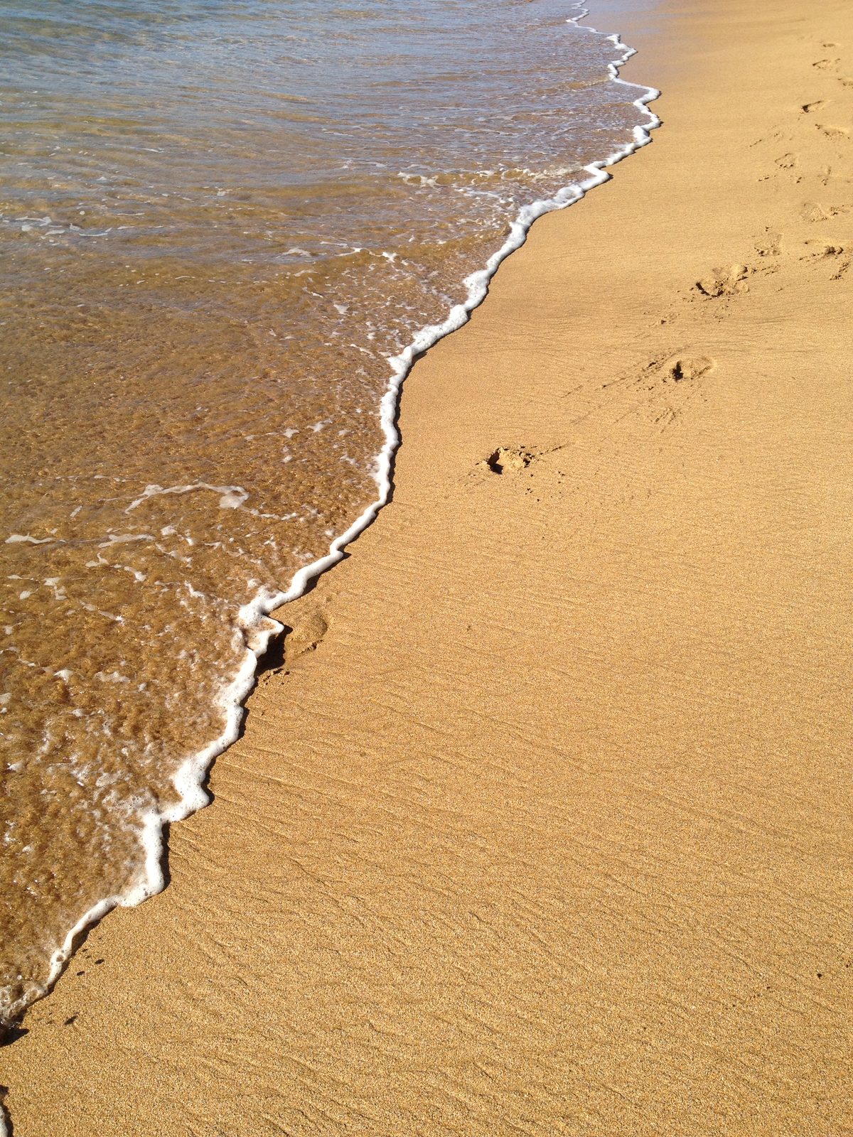 Footprints being eaten by the waves.