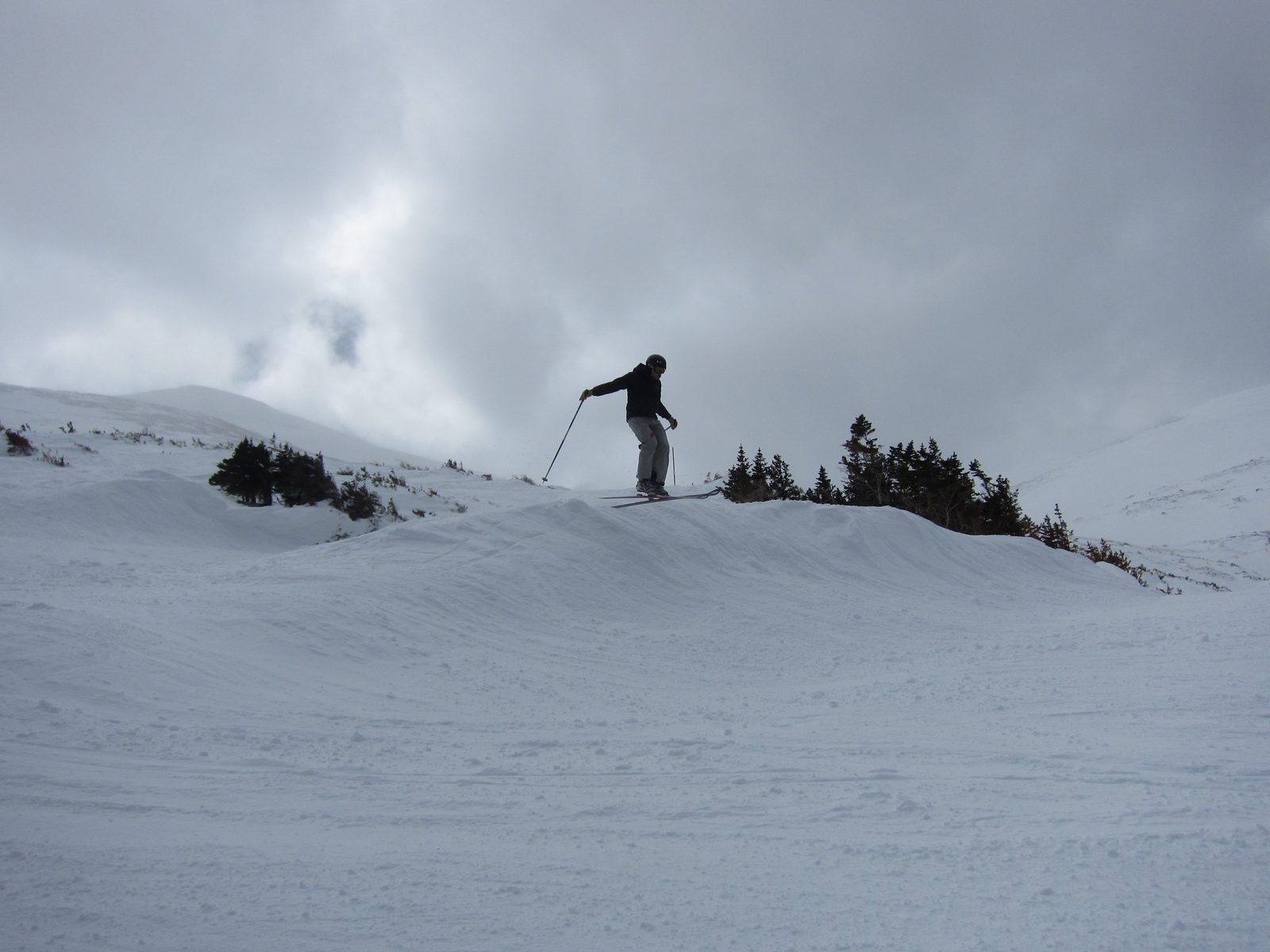 Andrew coming off the top of a jump with some great clouds behind.