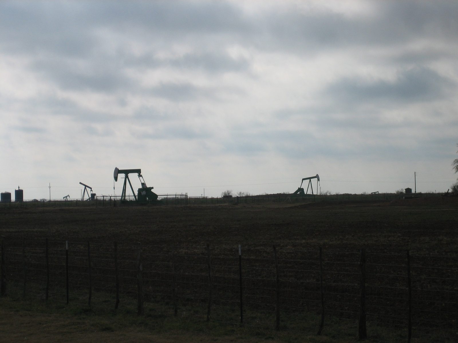 Oil derricks on the side of the road.  In some places, they stretched off to the horizon and the...