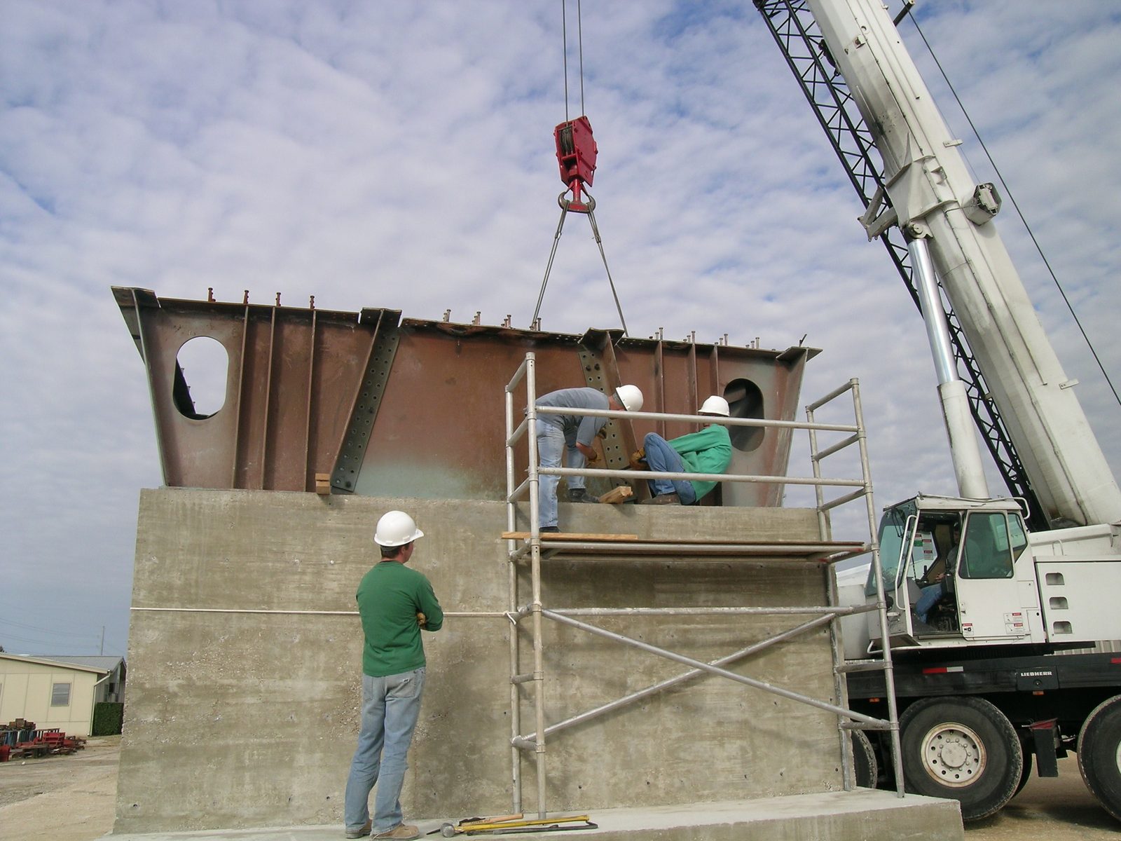 Tim and Mike work the girder into place (remember again: 60,000lbs) while Jim watches.