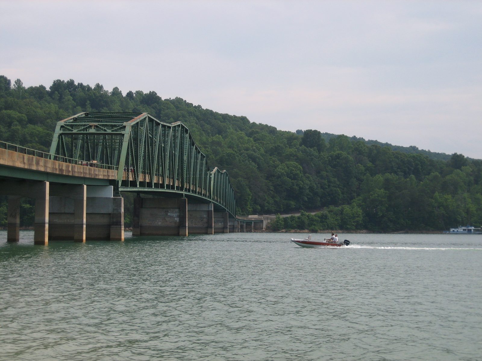 A motorboat passes under the bridge.