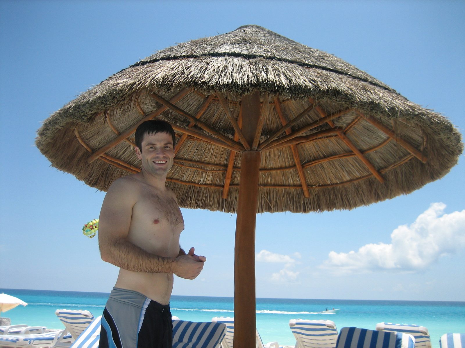 Jay standing at the pool with the beach in the background.