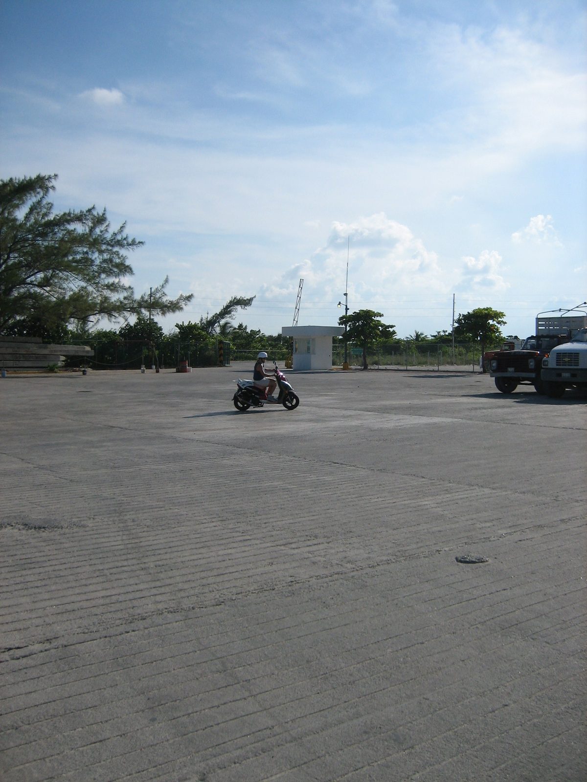 Catherine figures out how to drive the moped in an empty parking lot before letting Jay on.