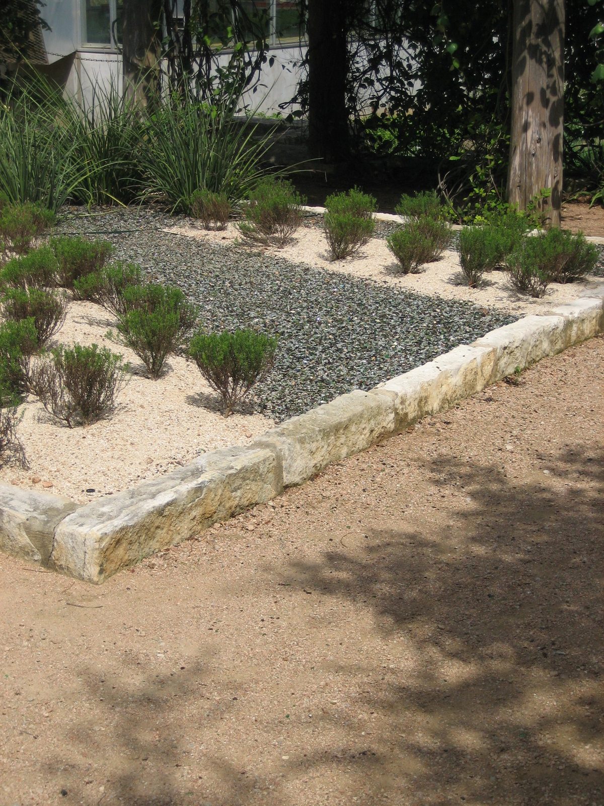 My favorite square of garden.  The dark "rocks" are actually broken pieces of glass bottles that...