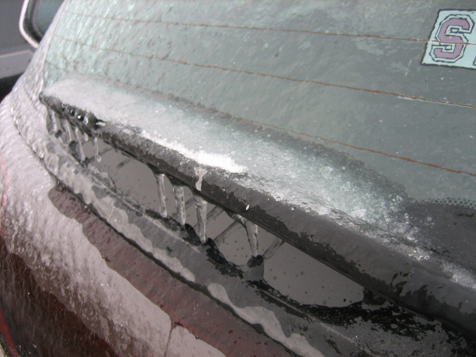 The back windshield wiper, firmly attached to the windshield.