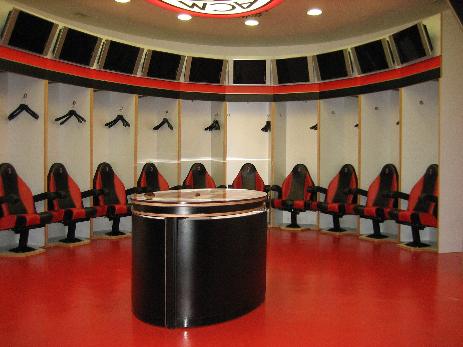 AC Milan locker room.  Note: leather shaped seats, individual locker space, hangers, etc.  How...