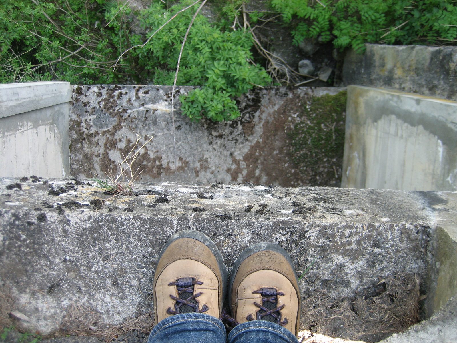 Looking at the ground below and my boots poking through the holes in the rail.