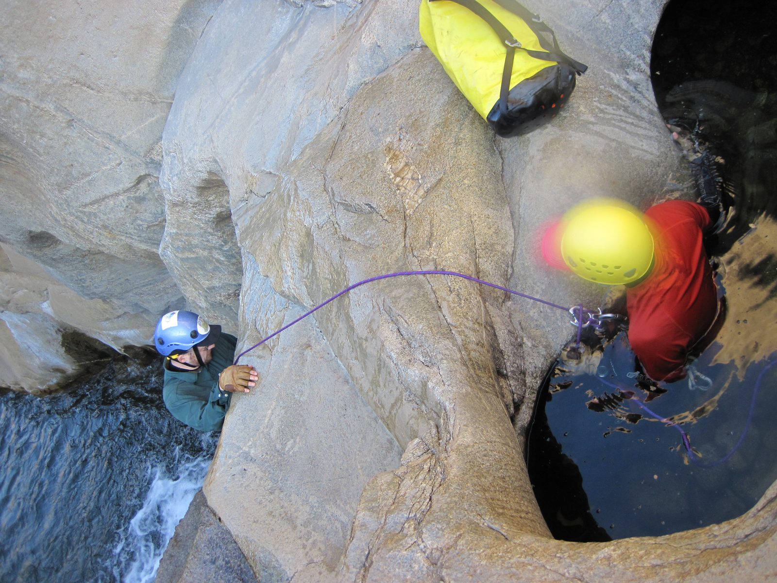 Joel rappels down carefully and checks the water depth.