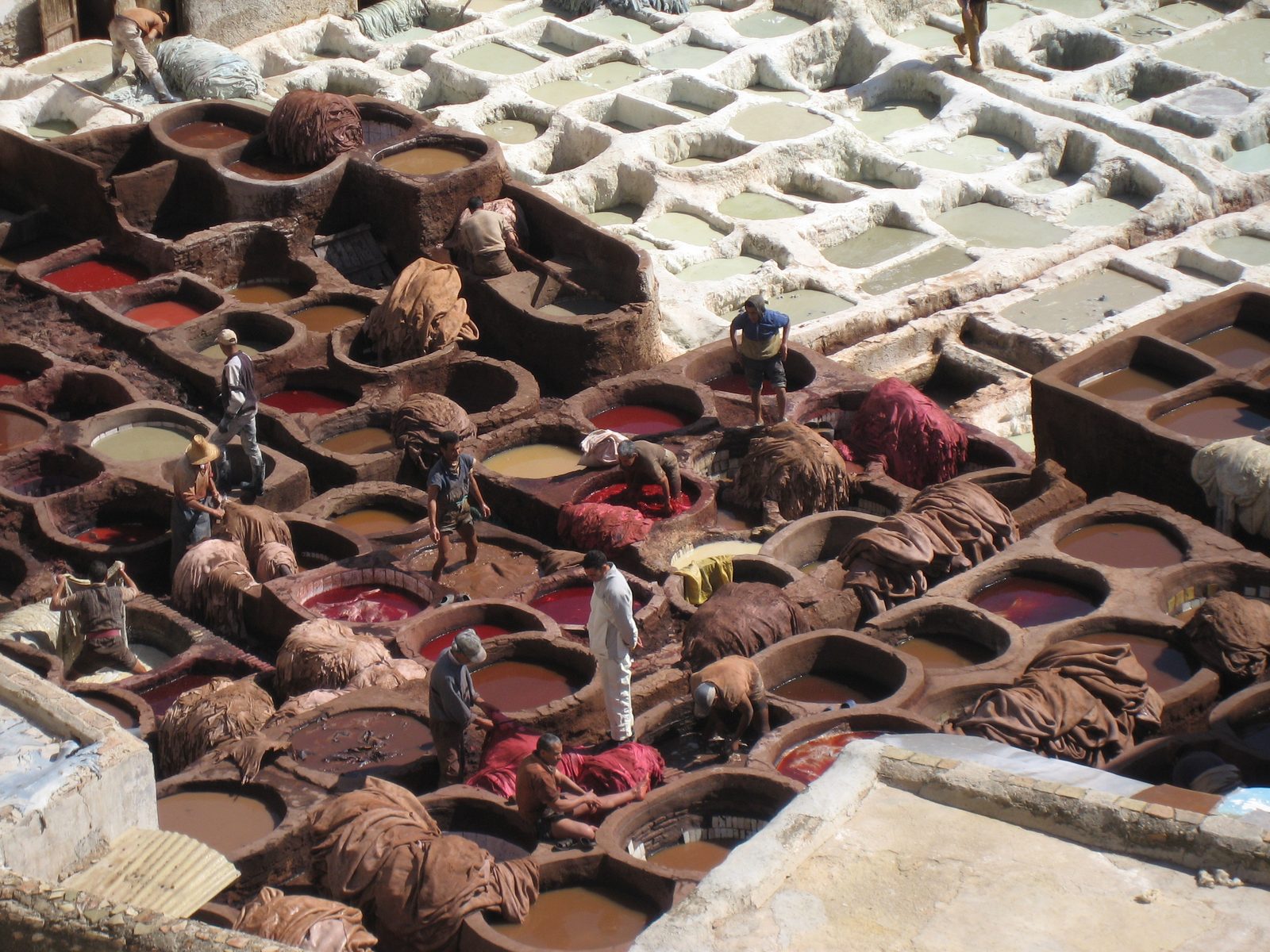 Tanners reducing their life expectancies in a tannery in Fes.  Notice that some of them are...
