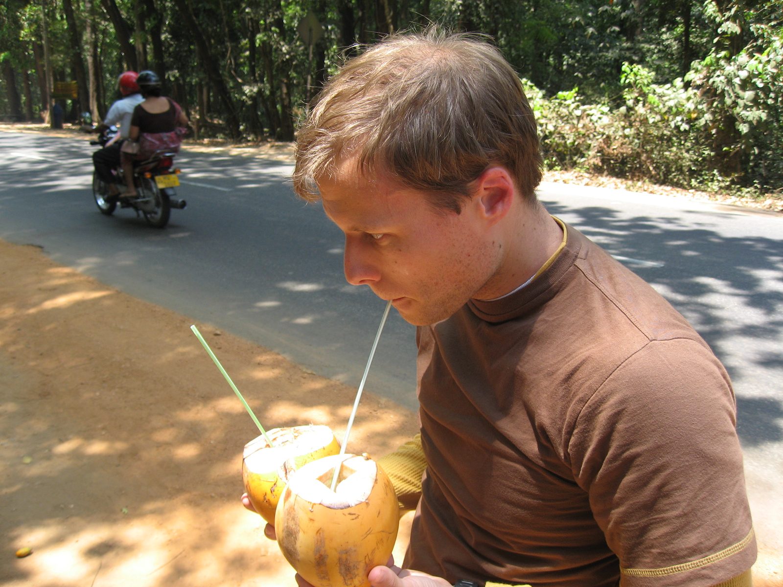 John double-fisting a pair of young coconuts at a roadside stand in Sri Lanka.