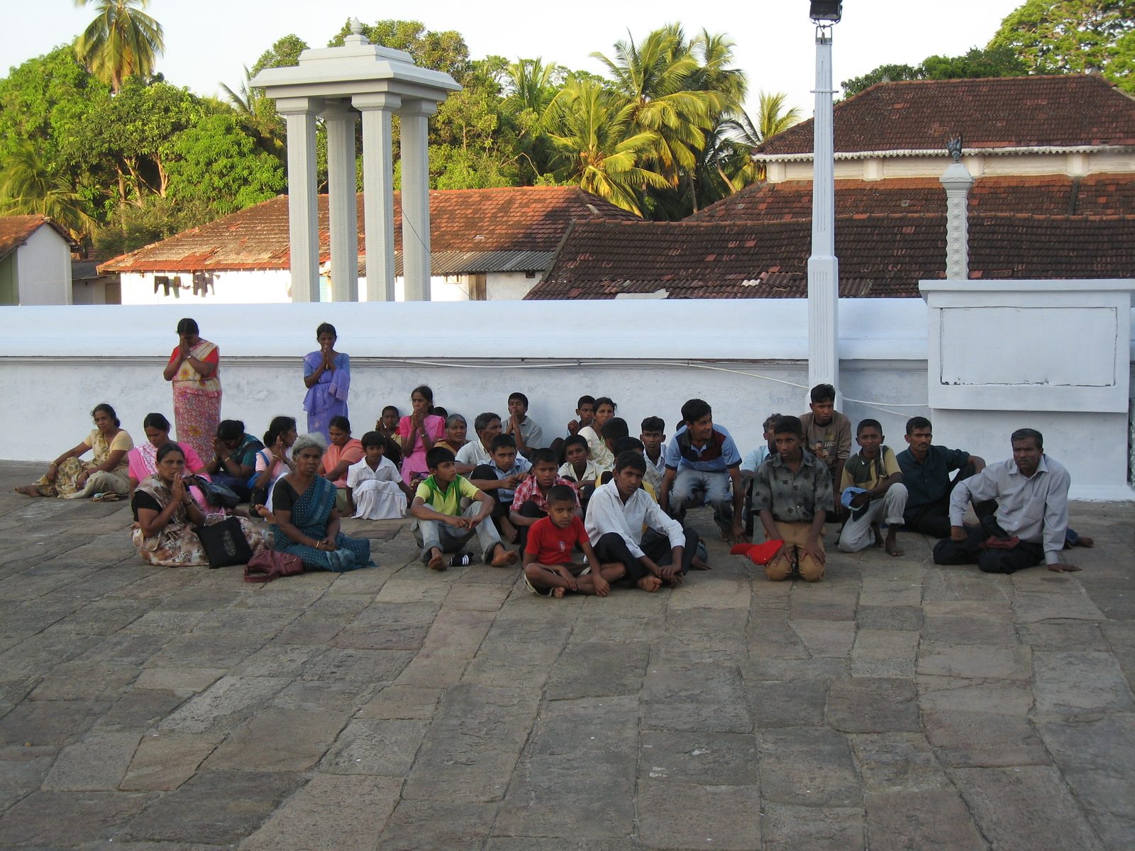A school class sits and either prays or spaces out.