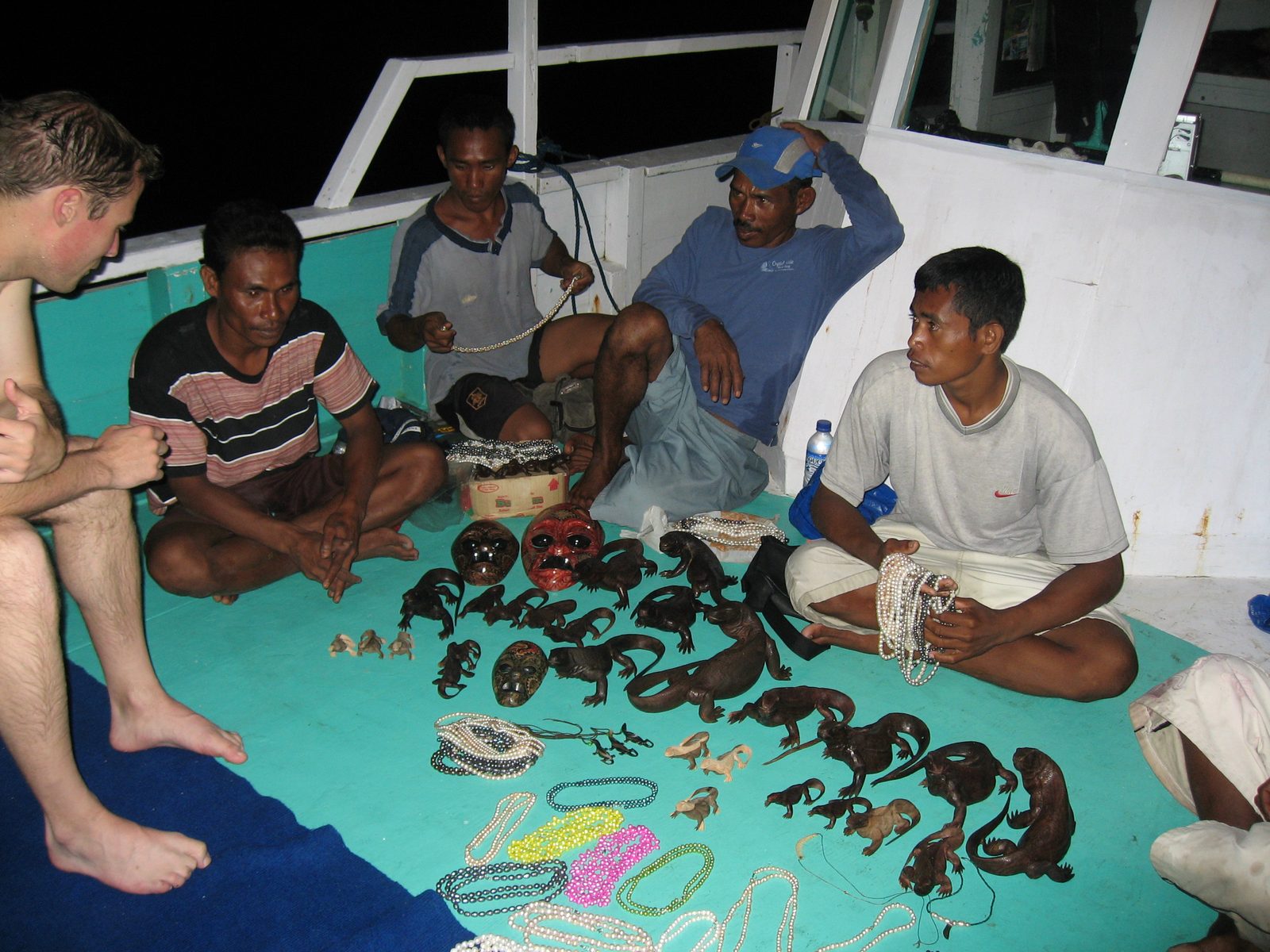 When we come back from snorkeling, we find that the locals have come aboard to peddle their...