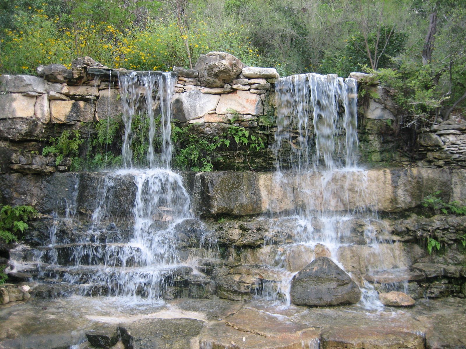A waterfall in the prehistoric garden area (complete with velocoraptor statue).