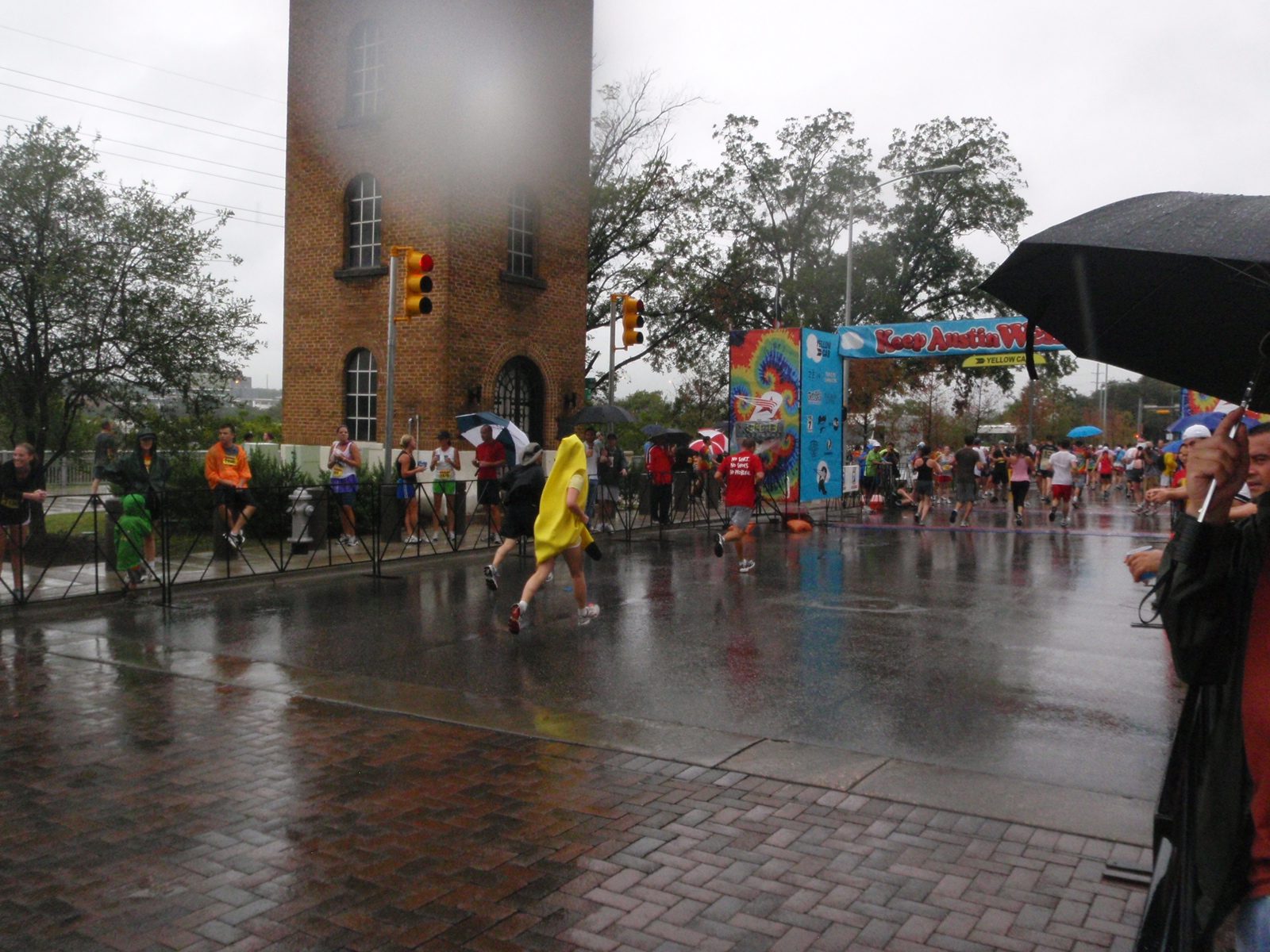 Monica finishing the Keep Austin Weird 5k, also with both feet off the ground and a cool reflection.