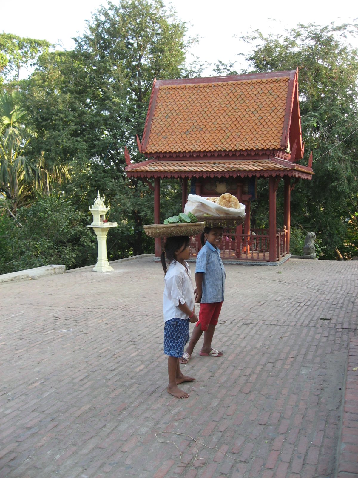 Little girls selling lotus flower seeds and bread, at Wat Phnom in Phnom Penh.