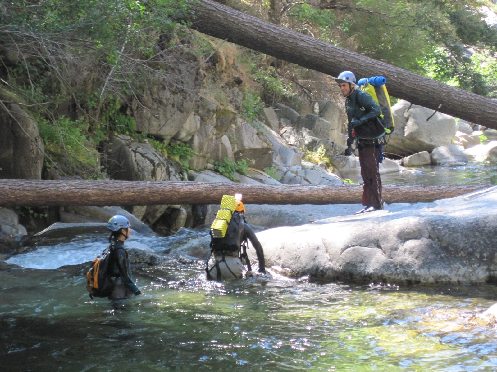Joel standing on shore as Yang and Monica get out of the water.