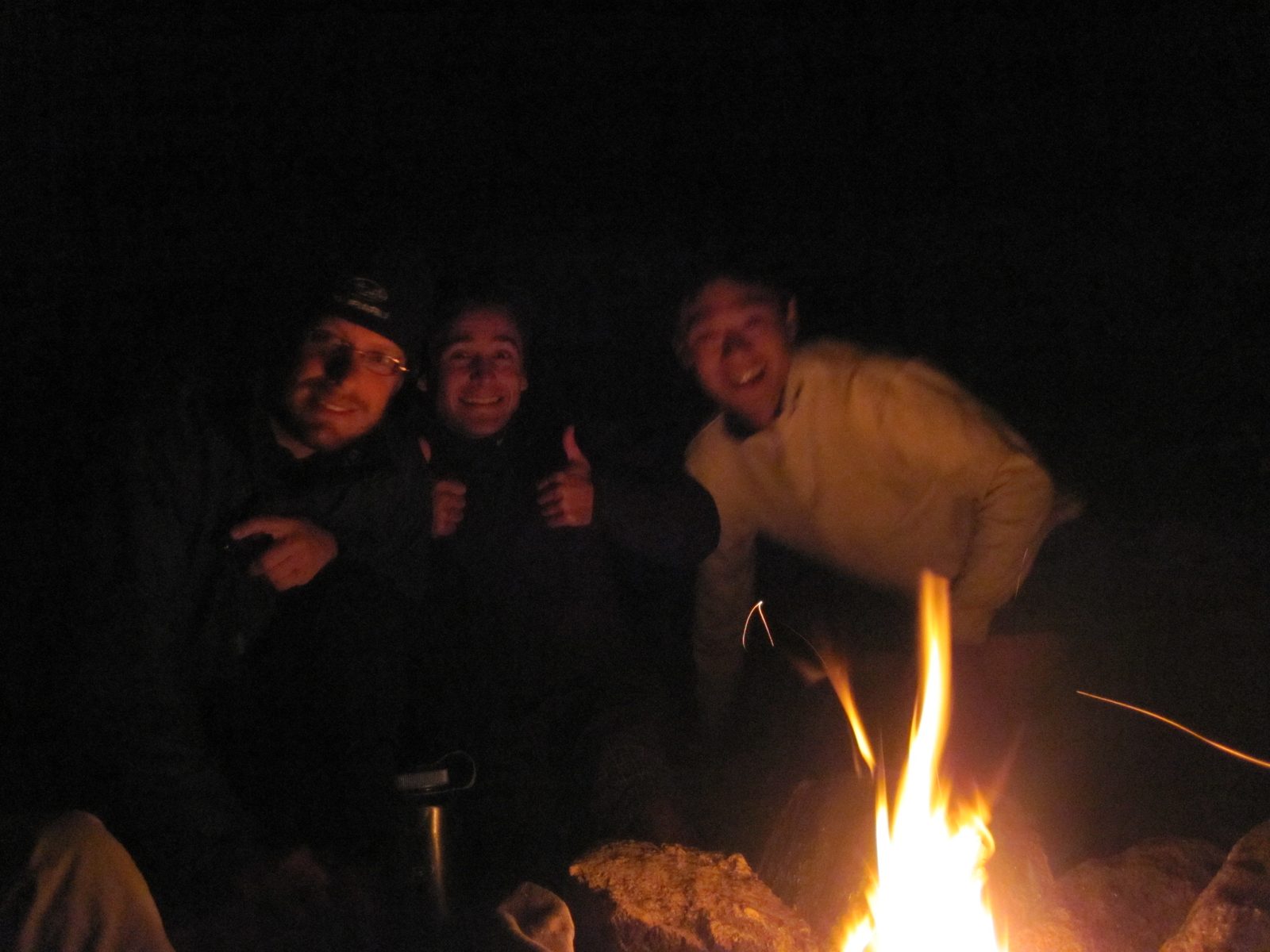 Joel, Vinnie and Yang around the campfire.