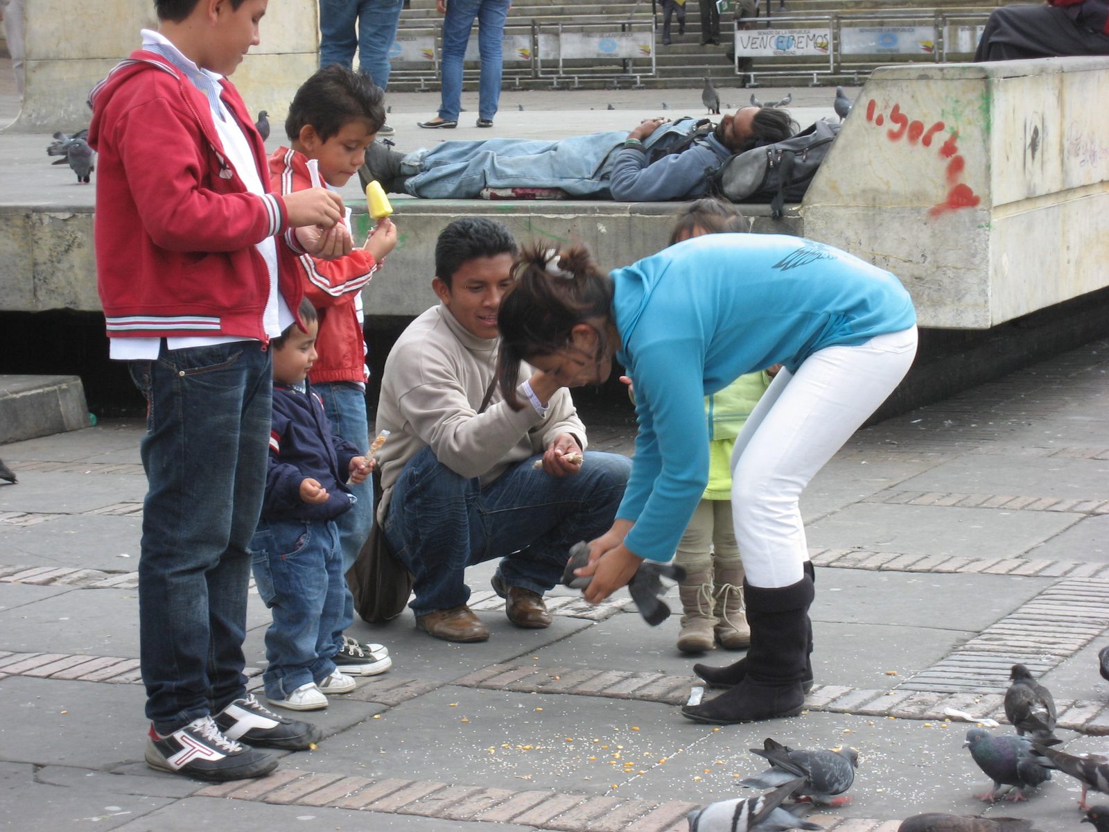 Kids playing with pigeons and eating food.  What could go wrong?
