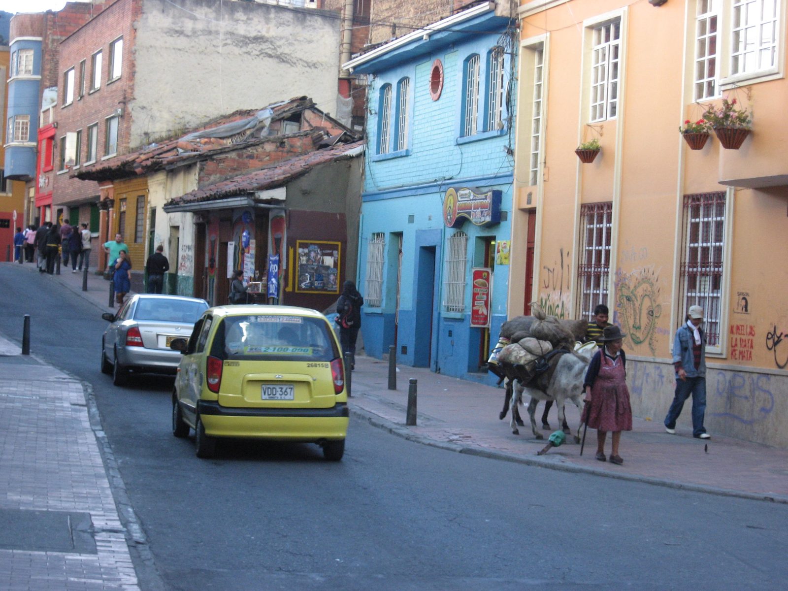 In the middle of La Candelaria, a peasant couple leads a donkey loaded with sacks of grain...