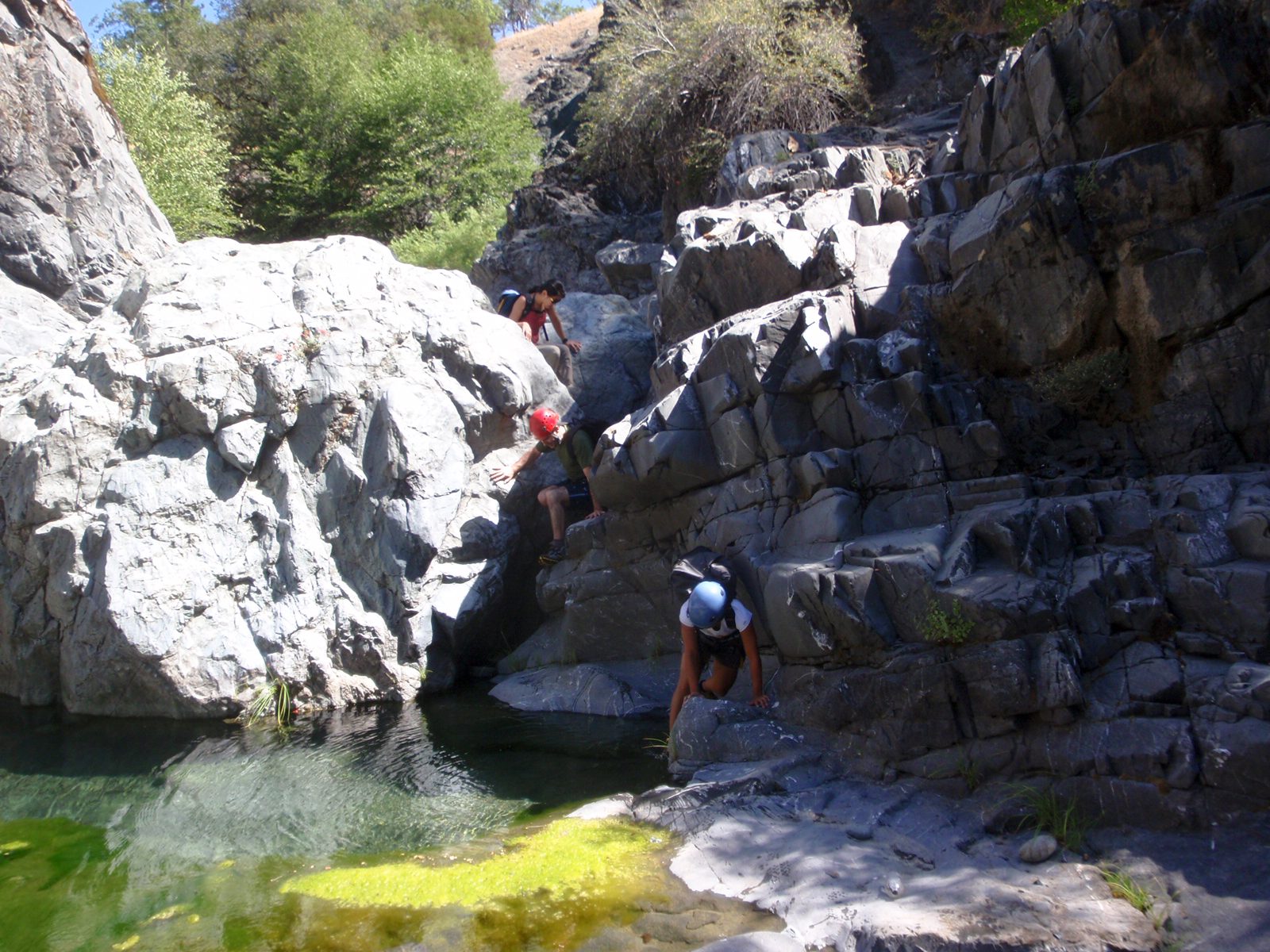 The crew scrambles over some boulders and through some bio-rich pools as we make our way down...