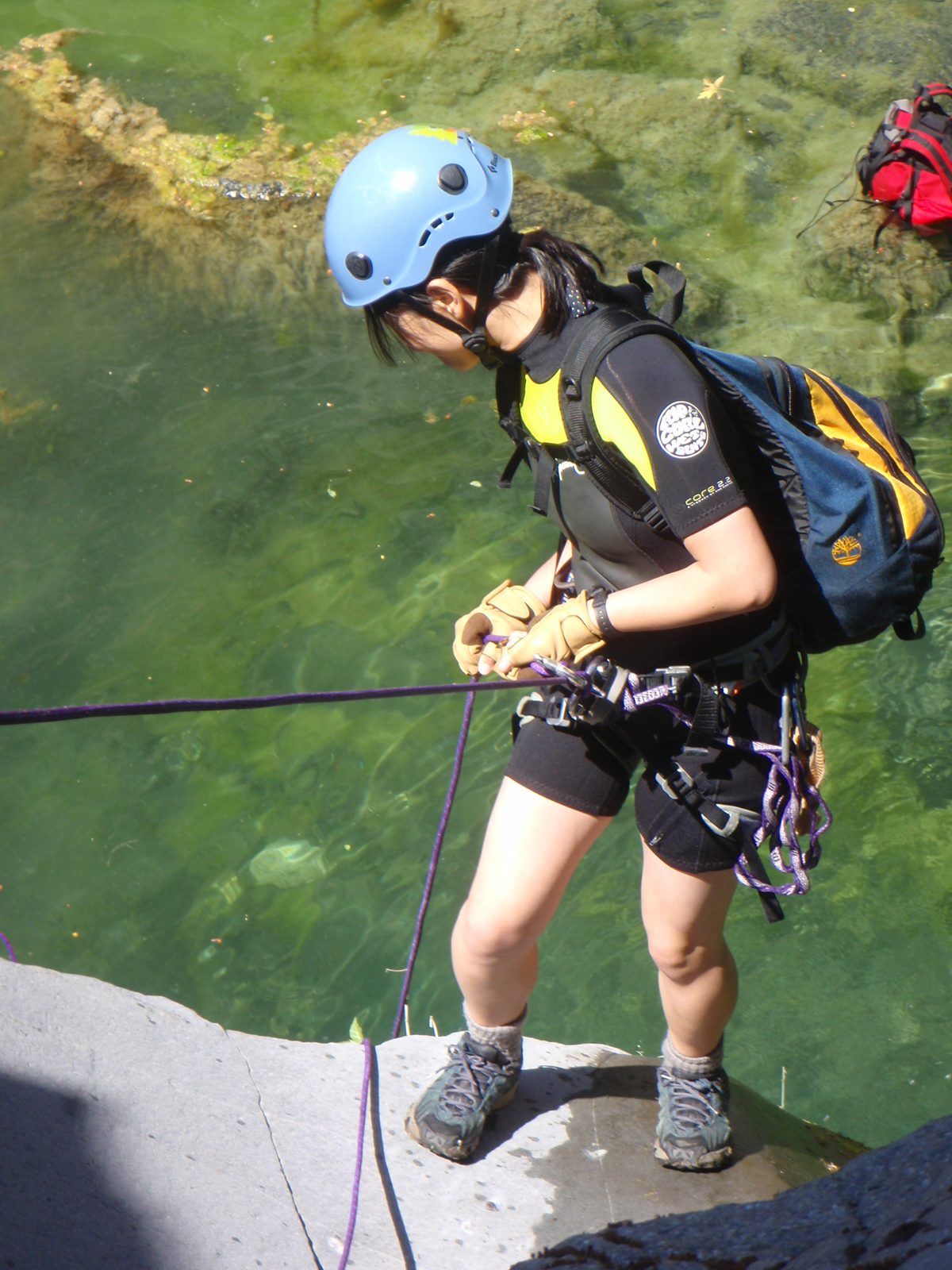 Monica going over the final lip of the first rappel.