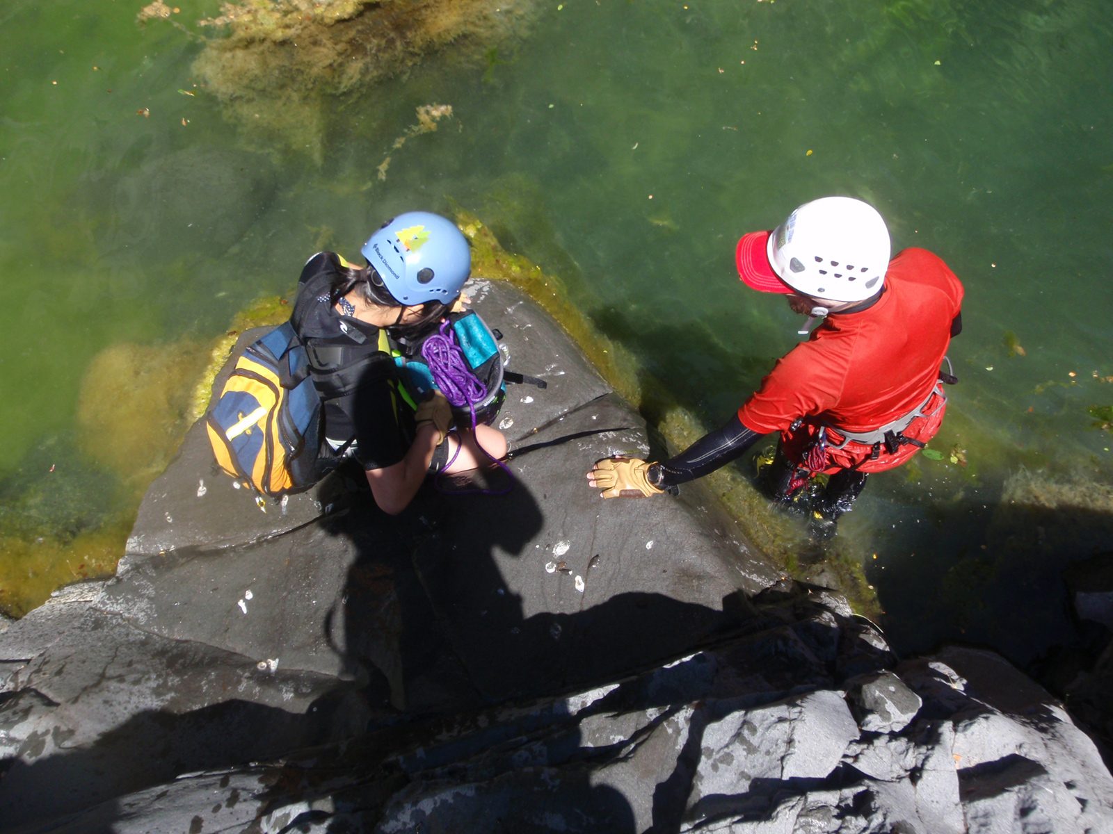 John helps Monica stow the rope after the first rappel.