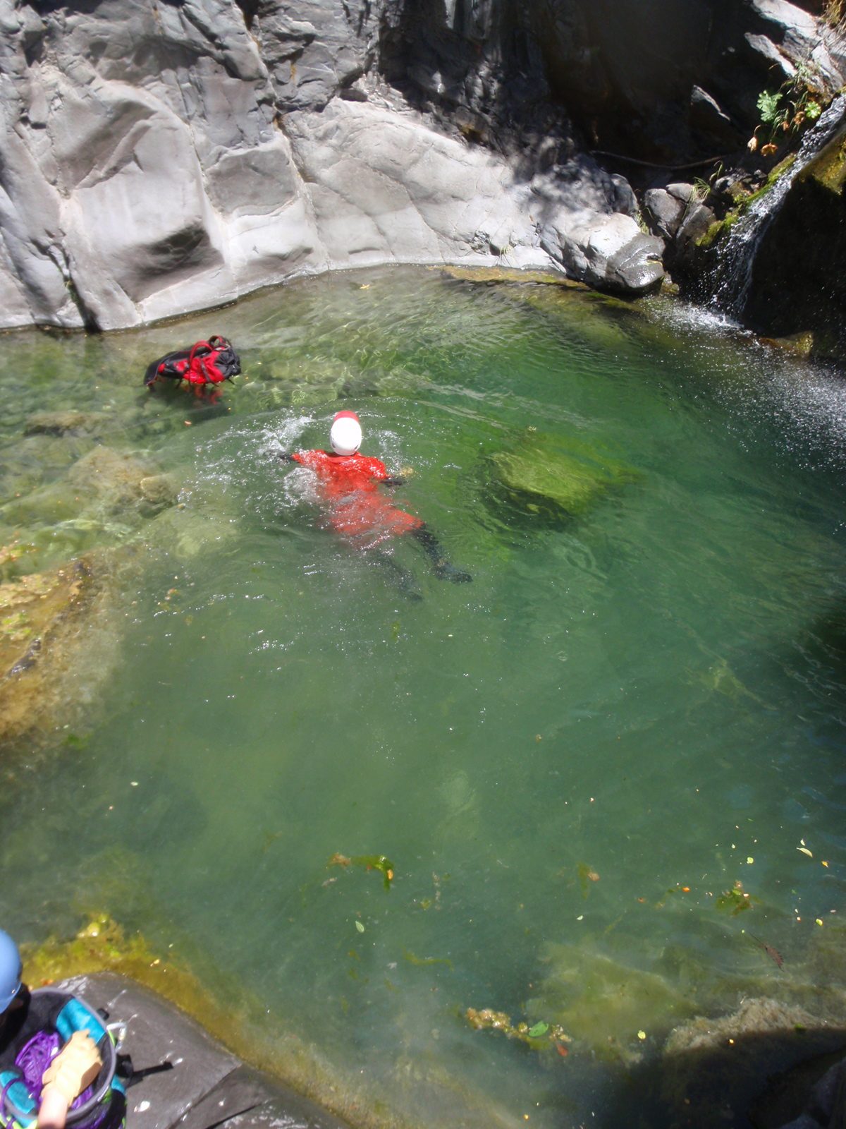 John retrieves his backpack which had floated off into swamp thing's side of the pool.