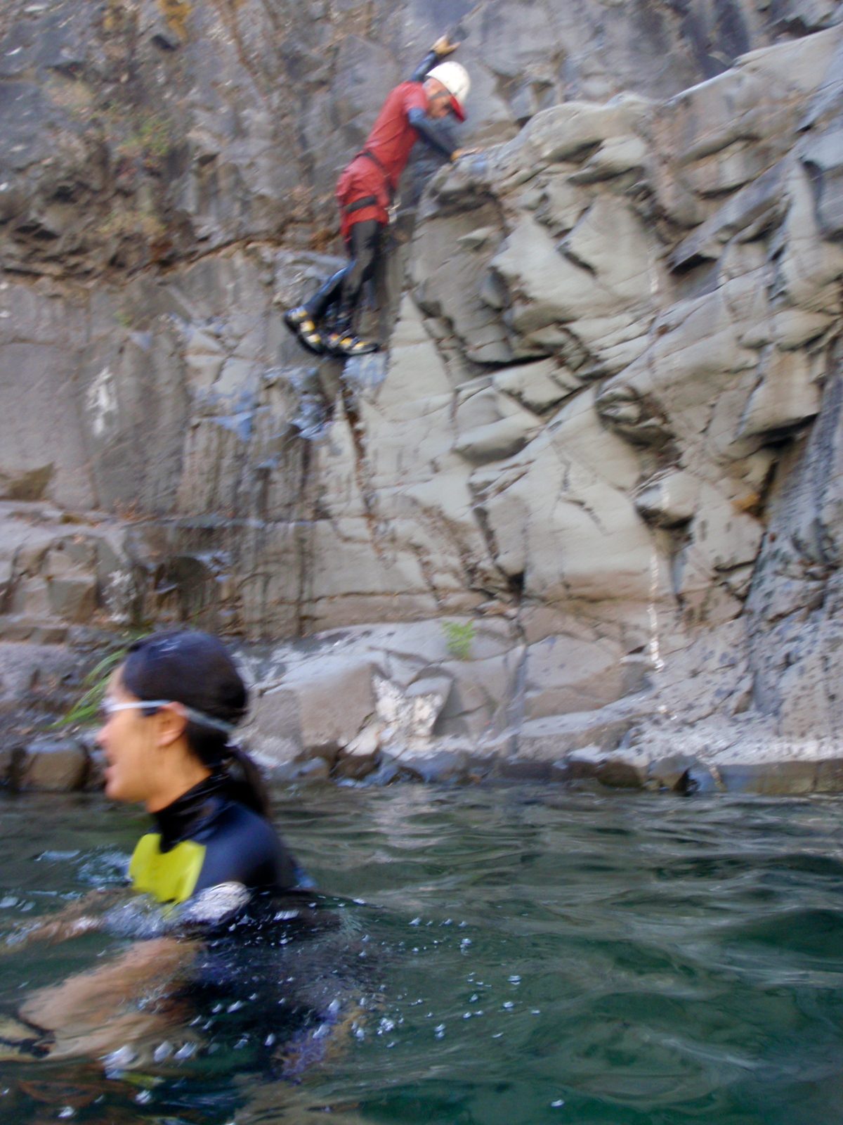 Monica in the pool while John climbs back to the jumping ledge.