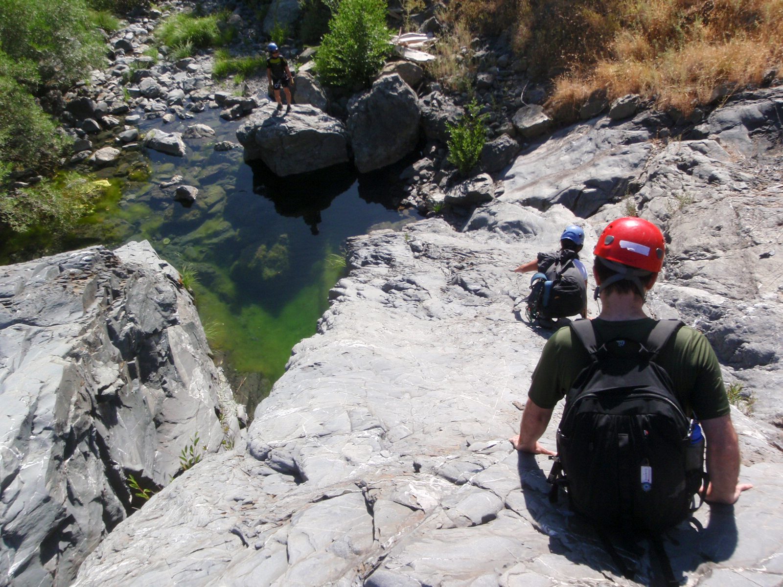 Monica leads the way down the final ramp of the canyon and Chris and Christina follow.  From...