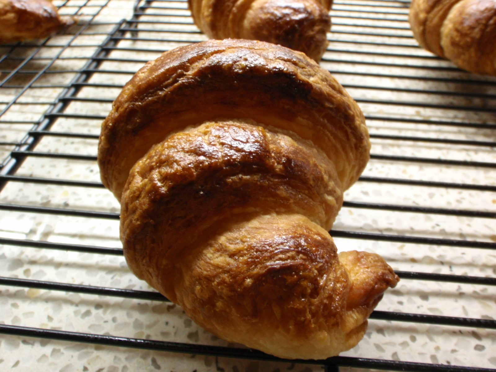 Croissant, viewed from the end.  Simply long triangles of layered dough which are rolled up,...