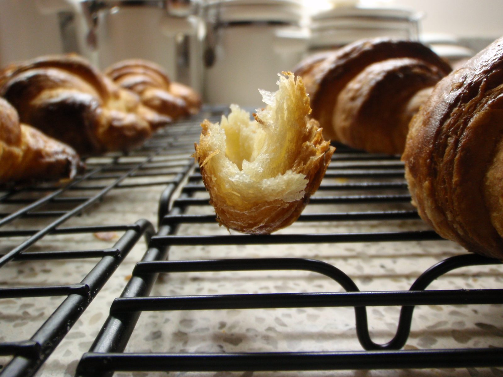 A croissant morsel, displayed lengthwise to reveal the countless layers made from butter-flour...