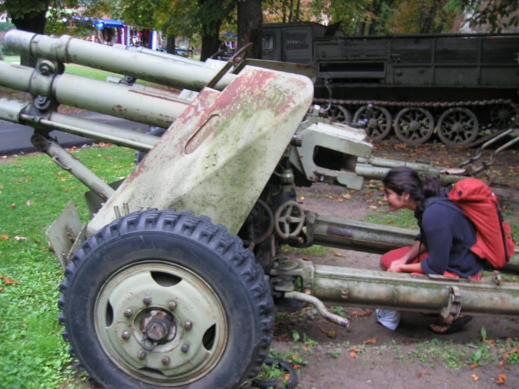 Jeanne inspecting the scope on an artillery gun.