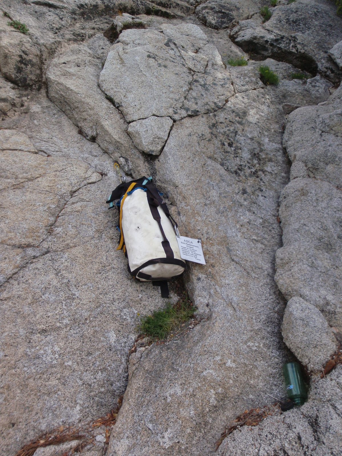 The ASCA campsite abounded with expensive climbing gear hanging all around, each bag affixed...