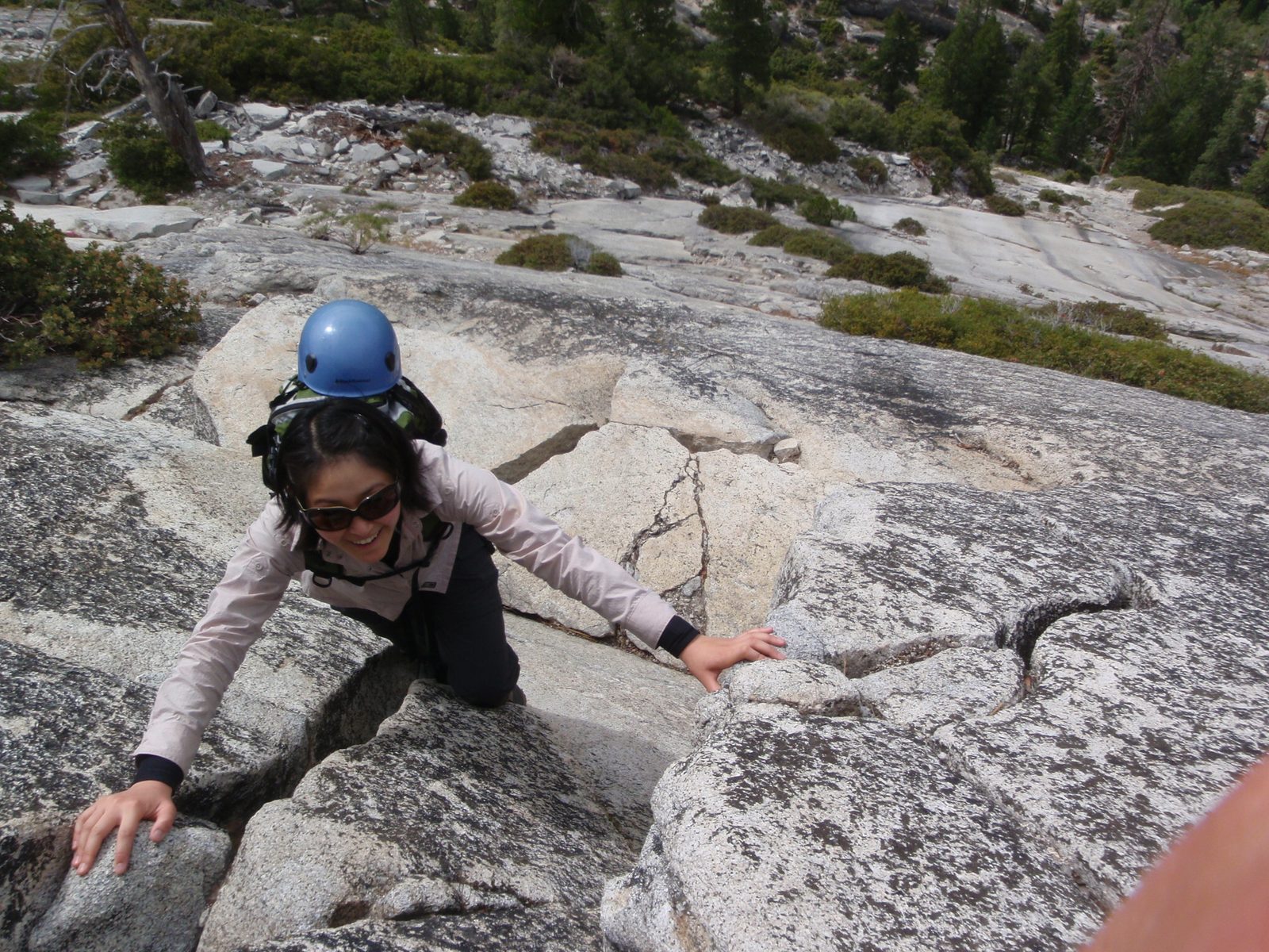 Monica climbing up to a higher ledge as we traverse the base of Half Dome looking for the start...