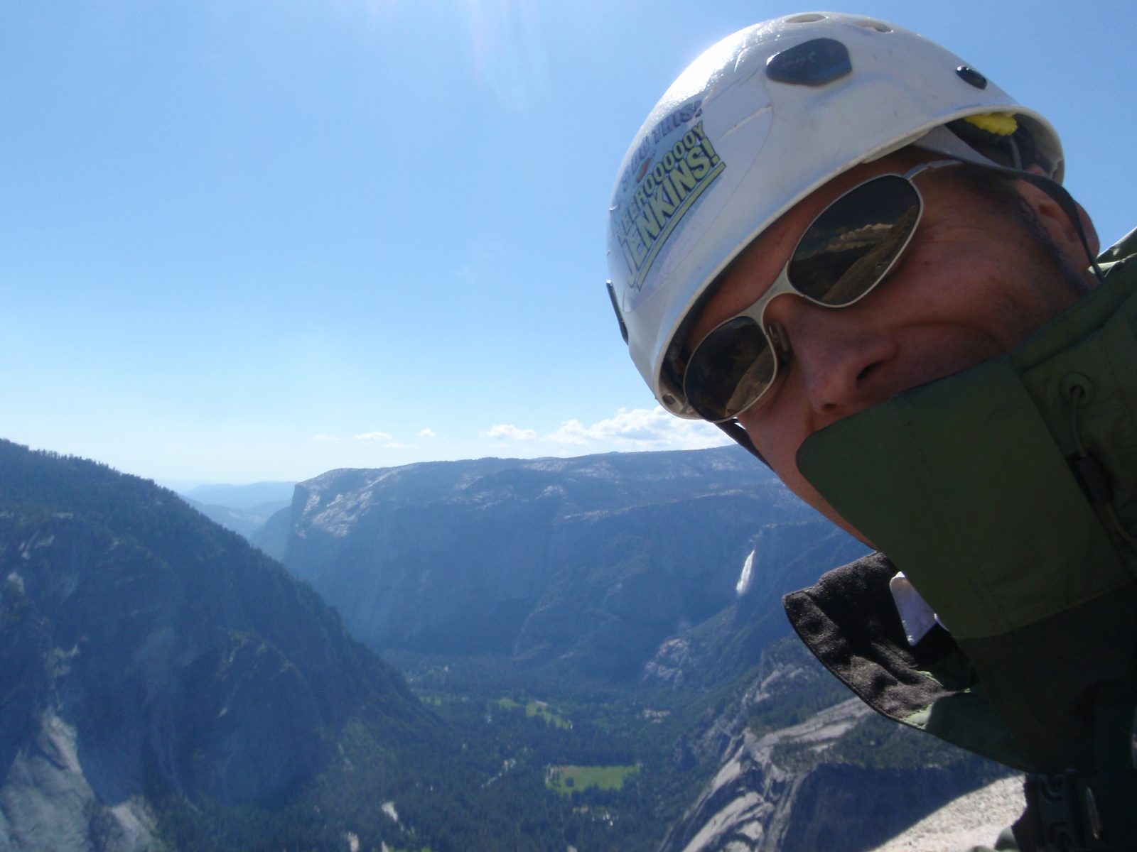 John, belaying from the top of pitch 6 with Yosemite Falls lit up by the sunlight in the...