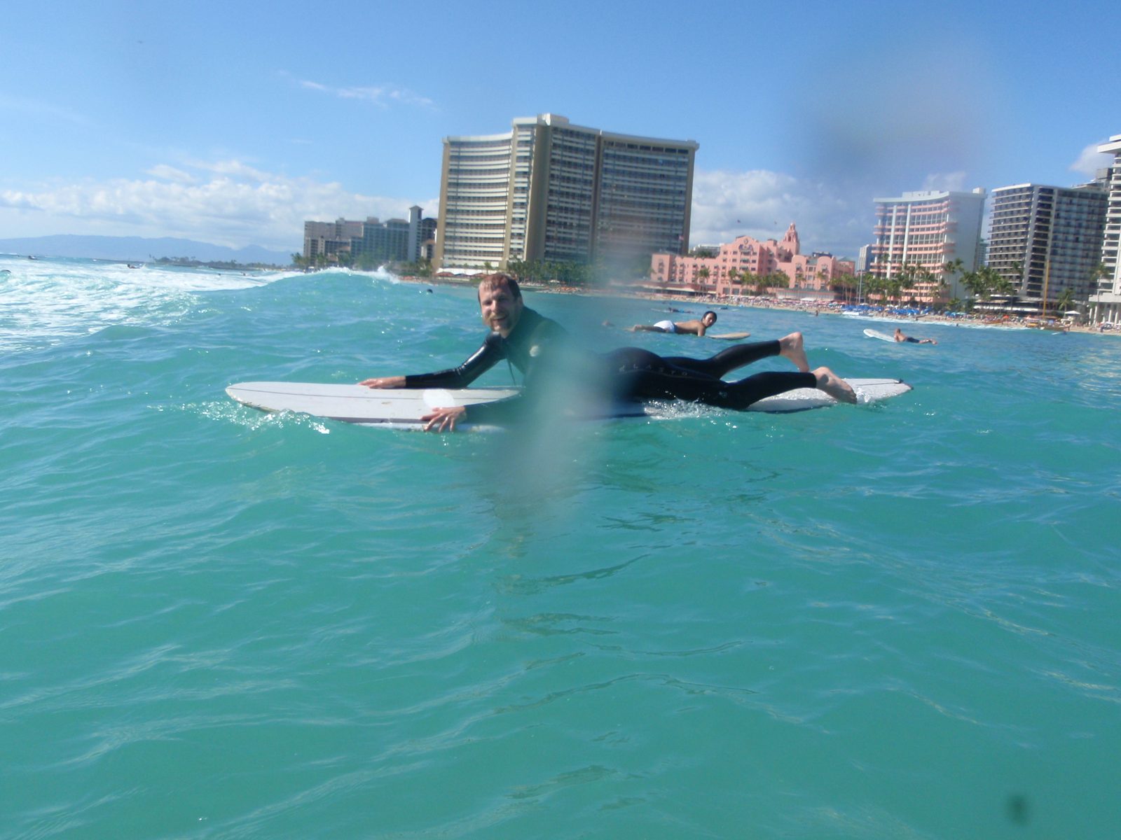 John, paddling out to sea to catch some waves.  Lydia tells me that the pink hotel, The Royal...