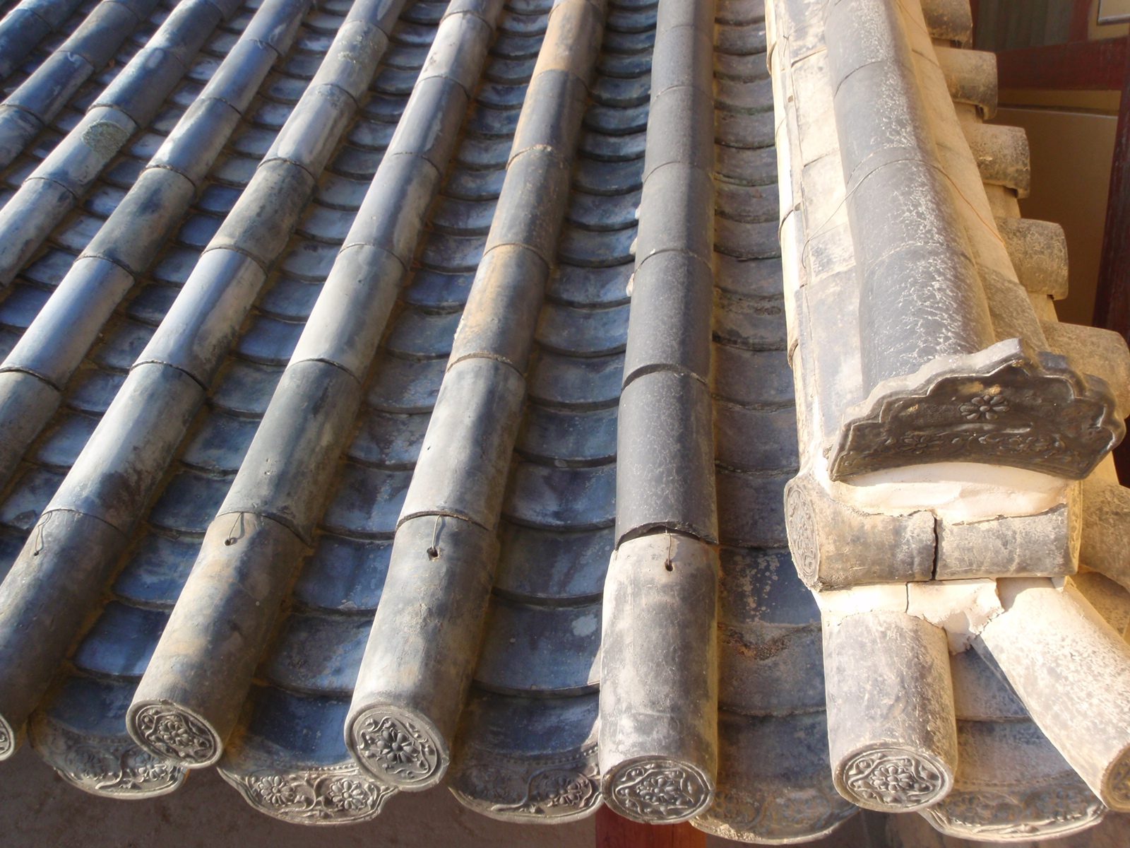 The clay tiles that cover the wooden roof.