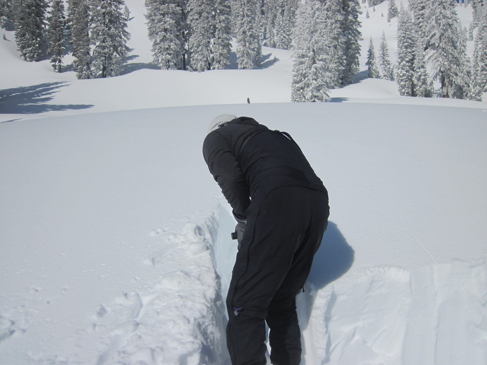 John digs a pit around a block of snow to perform a rutschblock test.