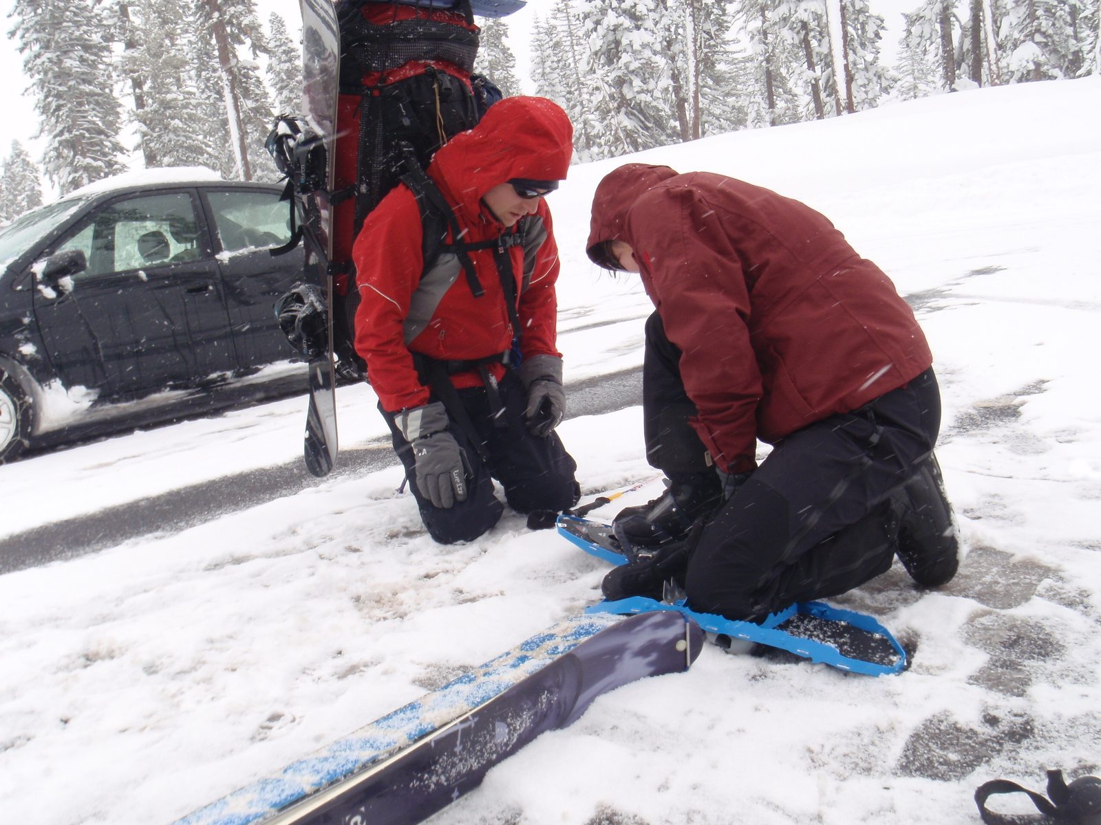 John helps Monica set up her snowshoes in the parking lot before heading out into the...